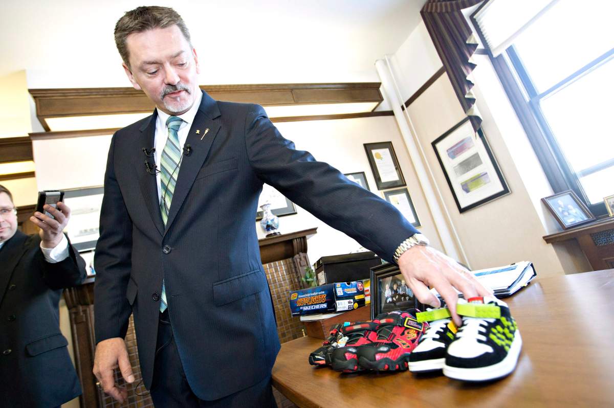 Alberta Finance Minister Doug Horner shows off shoes he bought for his grandchildren at pre-budget press conference in Edmonton on Wednesday, March 5, 2014.