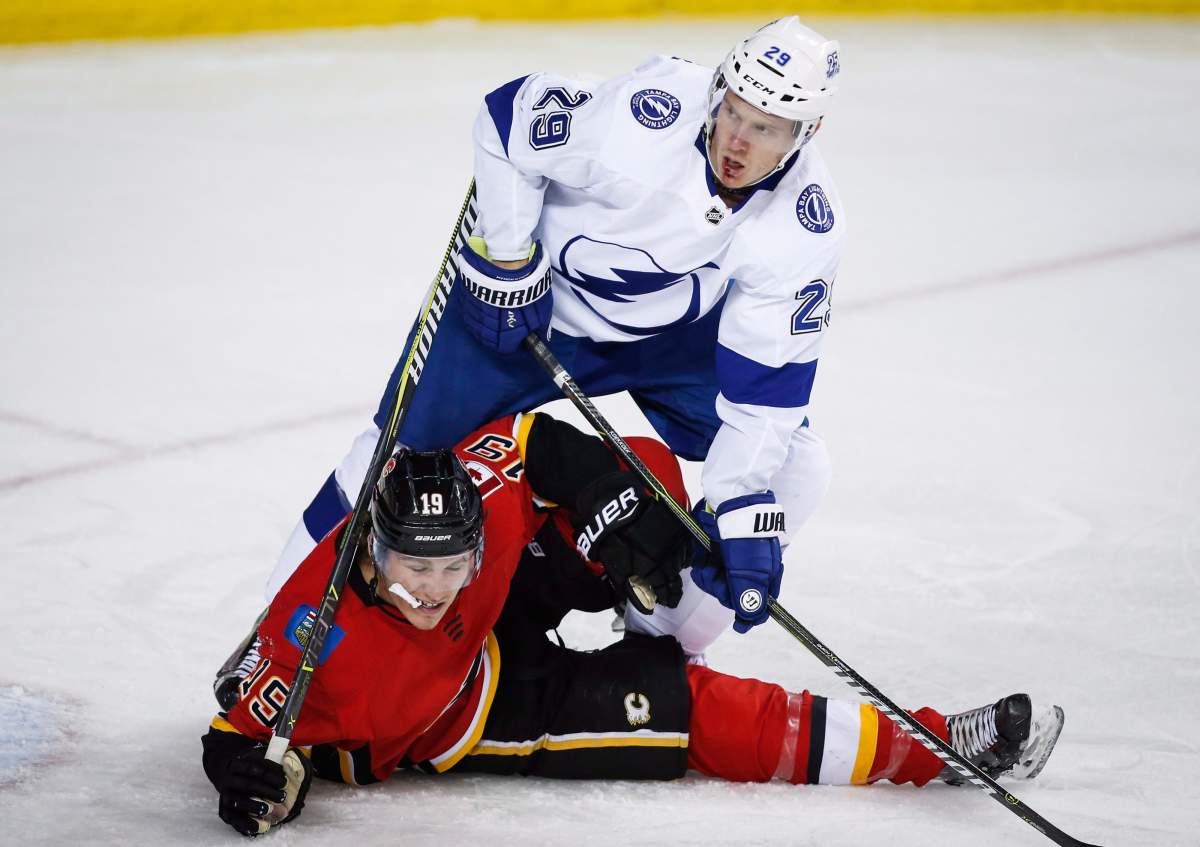 Tampa Bay Lightning's Slater Koekkoek, right, holds down Calgary Flames' Matthew Tkachuk during third period NHL hockey action in Calgary, Thursday, Feb. 1, 2018.THE CANADIAN PRESS/Jeff McIntosh.