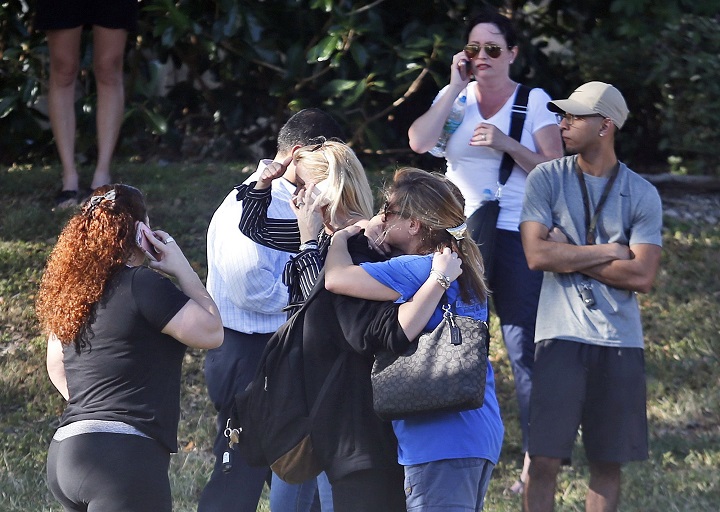 Anxious family members wait for news of students as two people embrace, Wednesday, Feb. 14, 2018, in Parkland, Fla. A shooting at Marjory Stoneman Douglas High School sent students rushing into the streets as SWAT team members swarmed in and locked down the building. 