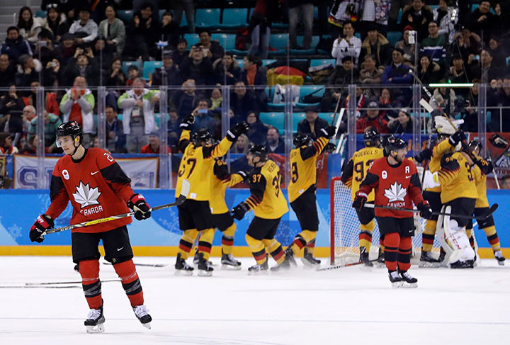 Mason Raymond of Canada, skates off as Germany players celebrate after the semifinal round of the men's hockey game against Canada at the 2018 Winter Olympics in Gangneung, South Korea, Feb. 23, 2018. 