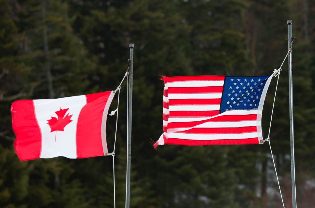 Photo of an American flag and a Canadian flag