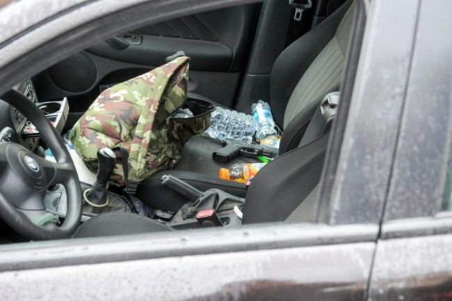 A Glock handgun sits on the seat of a black Alfa Romeo used by a man suspected of wounding several foreign nationals in a drive-by shooting,is blocked by police and Carabibieri enforcement at Macerata, on February 3, 2018 / AFP PHOTO