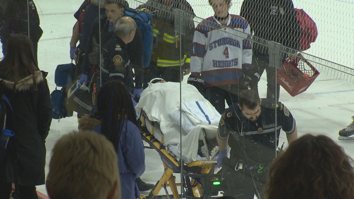 A player on the Sturgeon Heights Huskies is taken off the ice on a stretcher.
