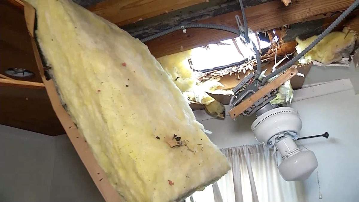 A hole is seen in the roof of a Miami home on Wednesday, Feb. 28, 2018 after a raft was dropped by a Royal Canadian Air Force helicopter during a training exercise.