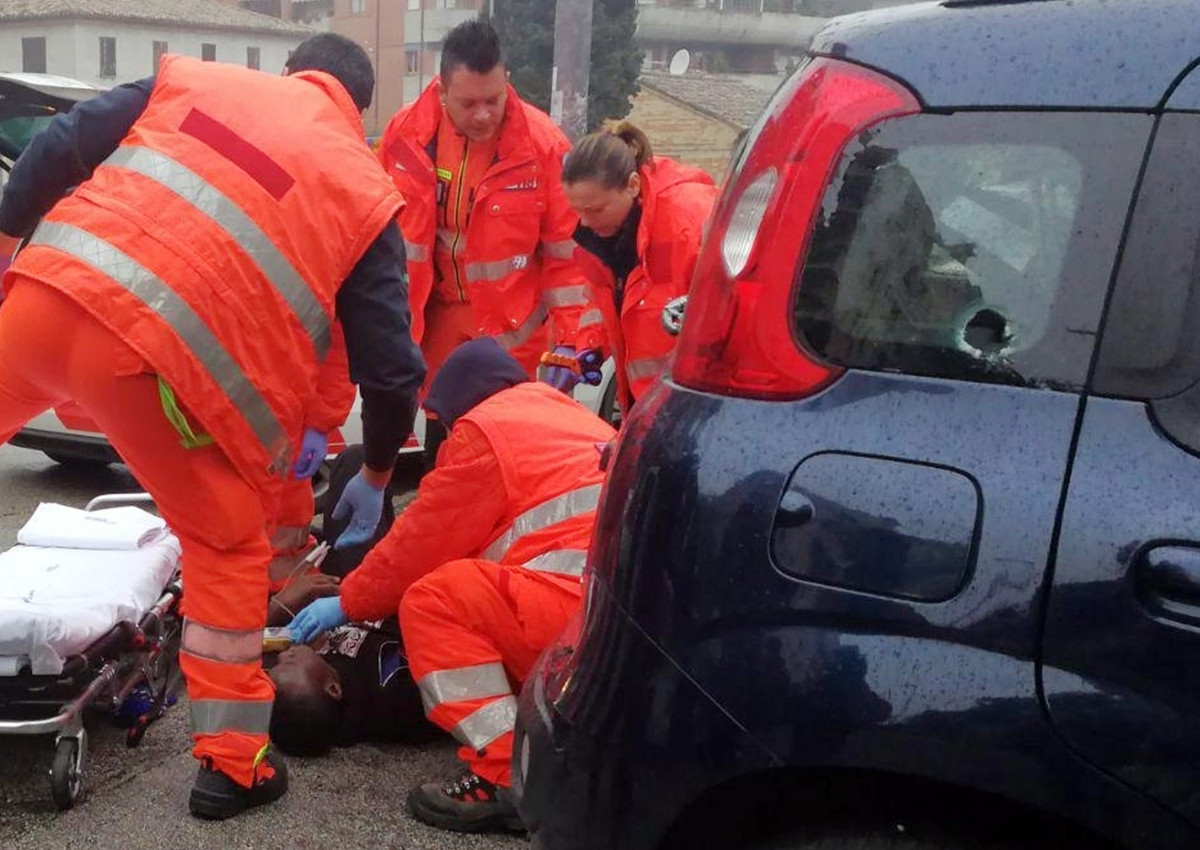 Italian Paramedics a wounded man after a shooting broke out in Macerata, Italy, Saturday, Feb. 3, 2018.