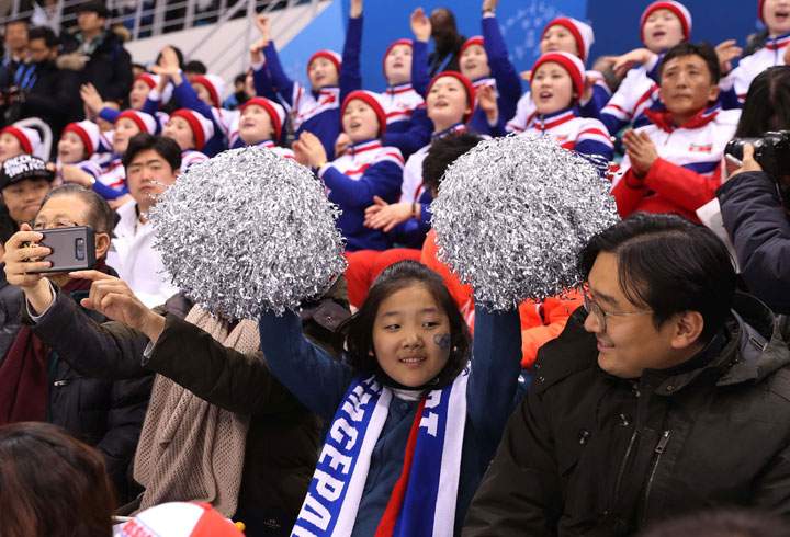 Fans cheer with North Korean cheerleaders.
