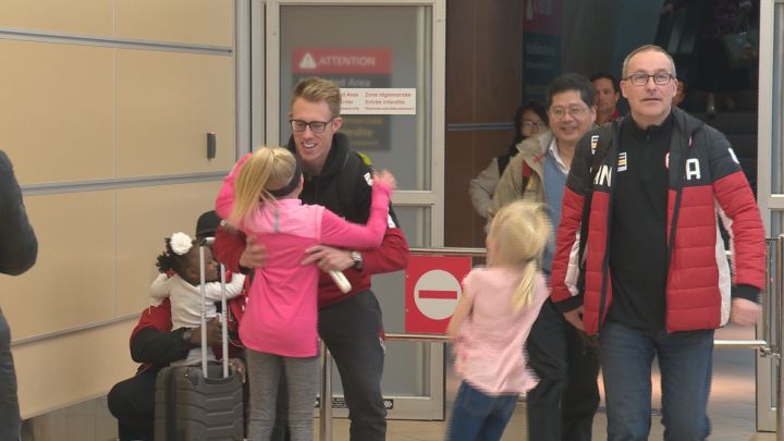 Curler Marc Kennedy greets his children at Edmonton International Airport on Monday after returning from the Winter Olympics.