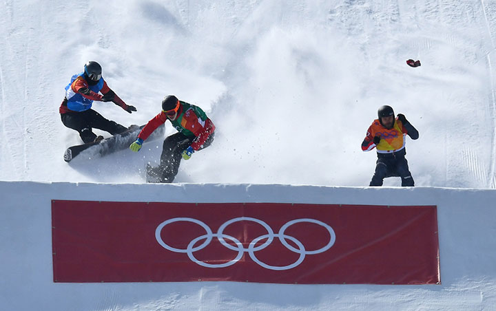 Kalle Koblet of Switzerland, Kevin Hill of Canada and Markus Schairer of Austria crash during the men’s snowboard cross at the Phoenix Snow Park, Pyeongchang, South Korea on Feb. 15, 2018. 