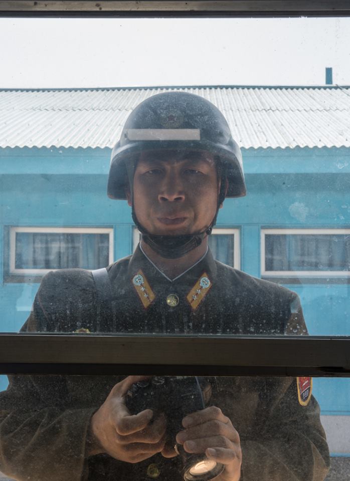 A North Korean man peering into a building in the Joint Security Area.