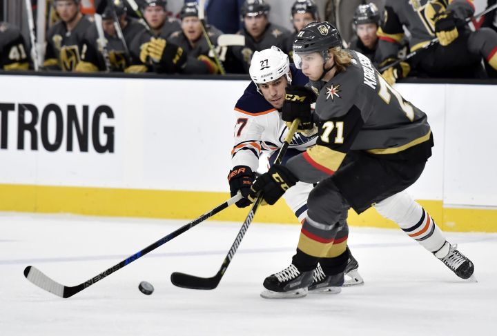 Edmonton Oilers left wing Milan Lucic (27) and Vegas Golden Knights center William Karlsson vie for the puck during the first period of an NHL hockey game Thursday, Feb. 15, 2018, in Las Vegas.