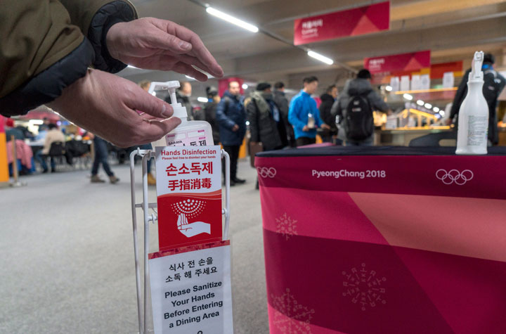 A man sanitizes his hands at the entrance to the media cafeteria, Wednesday, February 7, 2018 in Gangneung, South Korea. There areconcerns over the possible spreading of the norovirus, a contagious virus that causes stomach pain, nausea and diarrhea. The most effective way to stop the spread is to practice good hand-washing and personal hygiene. 