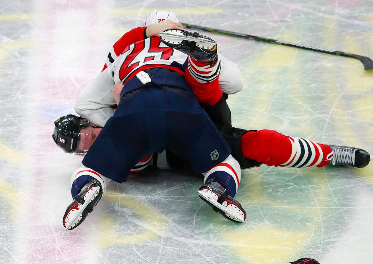 Devante Smith-Pelly (25) and Chicago Blackhawks defenseman Connor Murphy (5) fight during the third period of an NHL hockey game Saturday, Feb. 17, 2018, in Chicago.