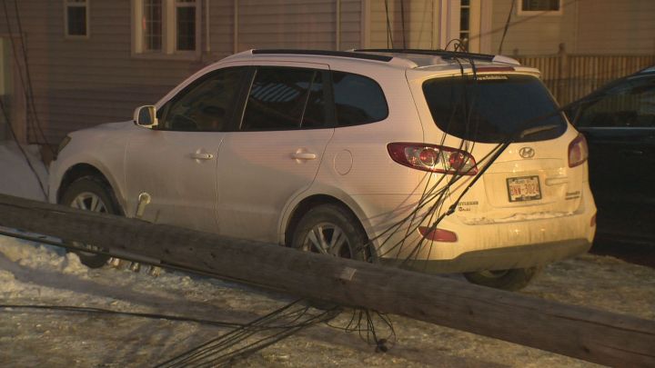 A woman was forced to spend 20 minutes in her SUV while it had live power lines on it after they came down when a truck crashed into a hydro pole in west Edmonton late Thursday afternoon.