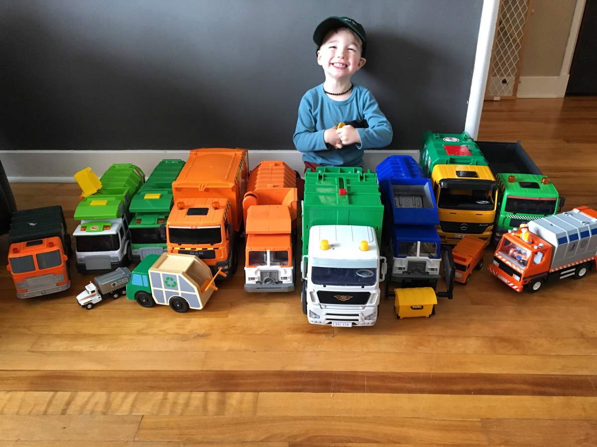 Hiro proudly displays his collection of toy garbage trucks.