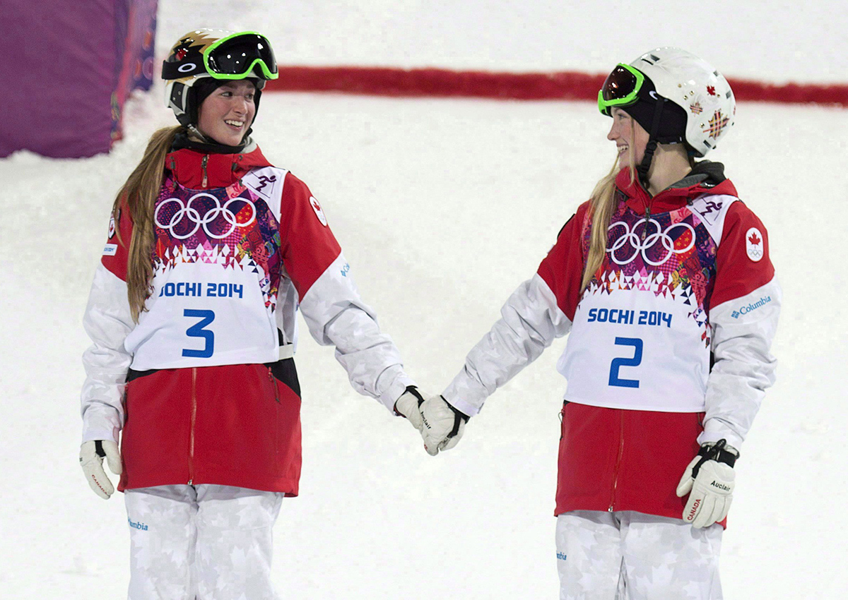 Canada’s Justine Dufour-Lapointe and Chloe Dufour-Lapointe holds hands before climbing on the podium after winning the gold and silver medals in the moguls at the Sochi Winter Olympics Saturday February 8, 2014 in Sochi, Russia.