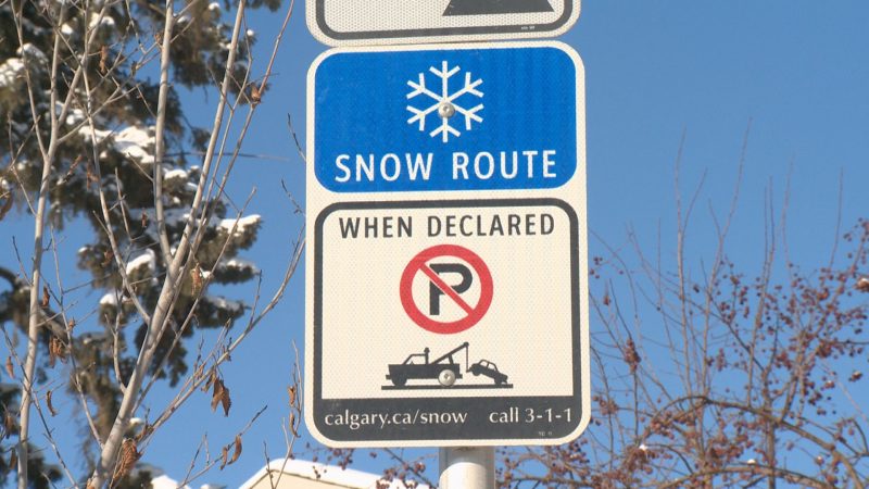 A snow route parking ban sign is shown.