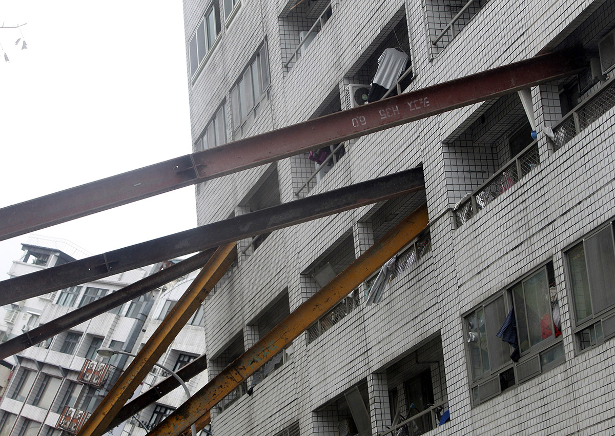 Several steel pillars support to an apartment building collapsed and leaning after a strong earthquake in Hualien County, eastern Taiwan, Thursday, Feb. 8, 2018.