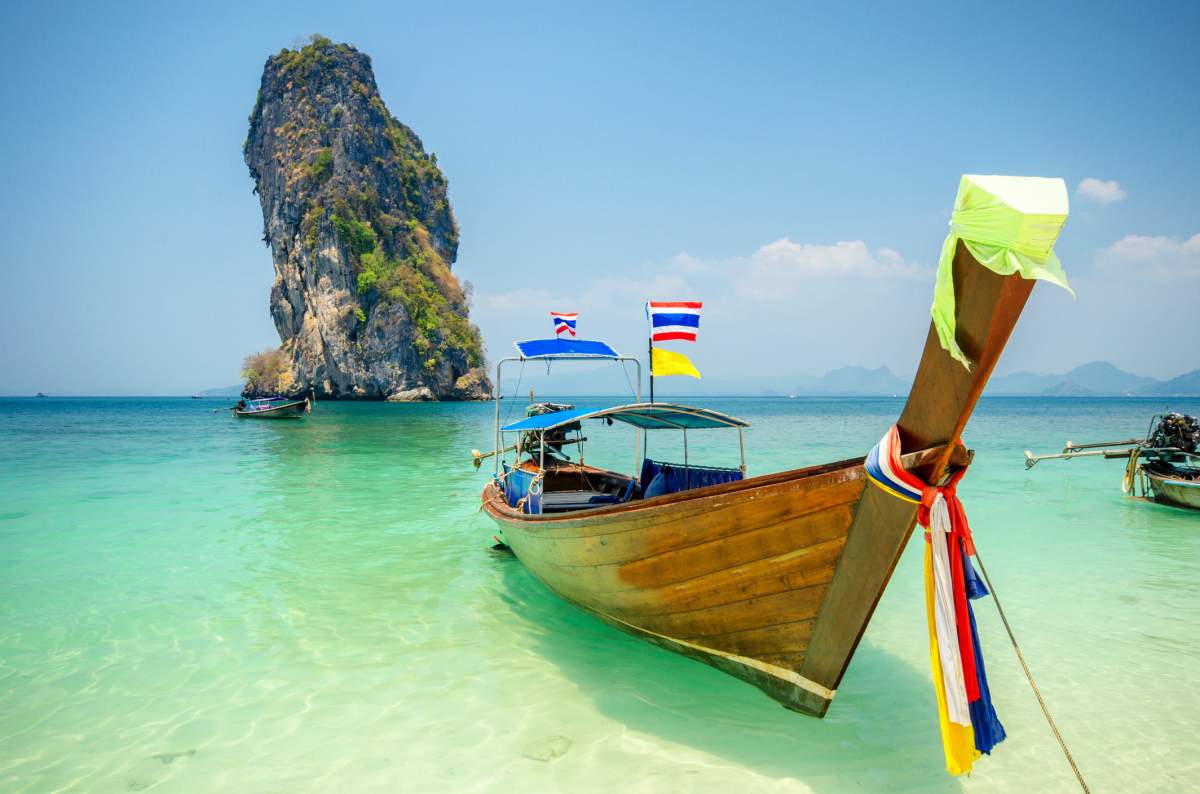 Long tailed boat Ruea Hang Yao in front of island background in Phuket, Thailand.