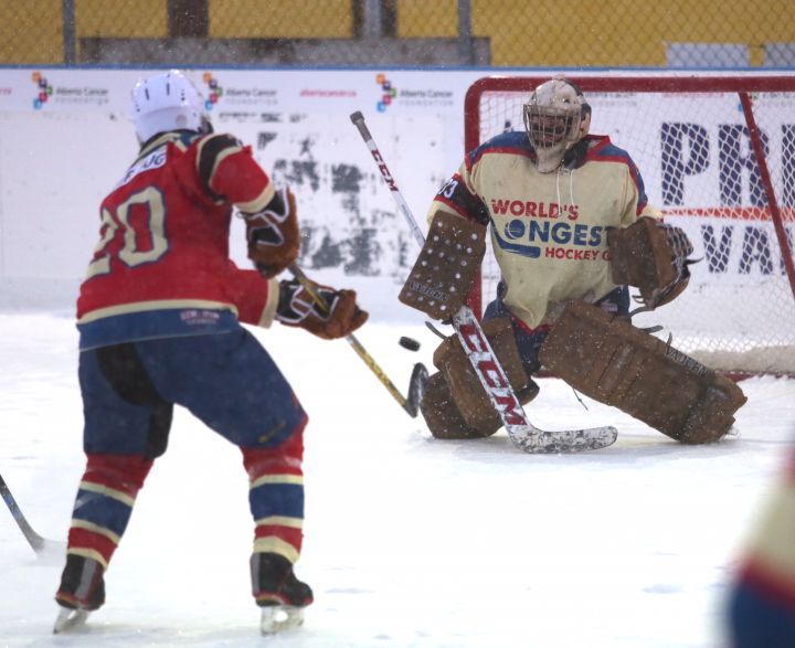 Players skating in snowy conditions at the World’s Longest Hockey Game Wednesday, Feb. 14, 2018.