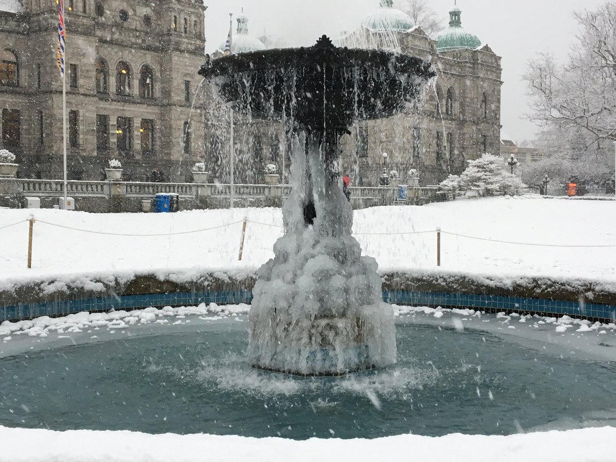 Snow falls around a frozen fountain in front of the B.C. legislature in Victoria on Wednesday.