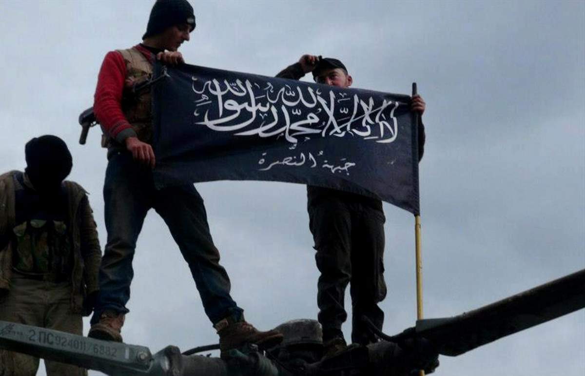 A Jan. 11, 2013, citizen journalism image provided by Edlib News Network shows rebels from Syrian al-Qaida affiliate Jabhat Al-Nusra waving brigade flag.