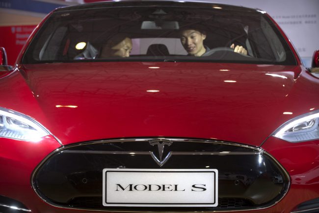In this April 25, 2016 file photo, a man sits behind the steering wheel of a Tesla Model S electric car on display at the Beijing International Automotive Exhibition in Beijing. 


