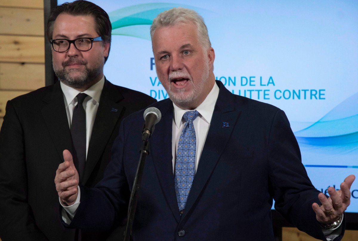 Quebec Premier Philippe Couillard speaks at a news conference at the end of a forum on diversity and anti-discrimination, Tuesday, December 5, 2017 in Quebec City. Quebec Immigration, Diversity and Inclusiveness Minister David Heurtel, left, looks on. 