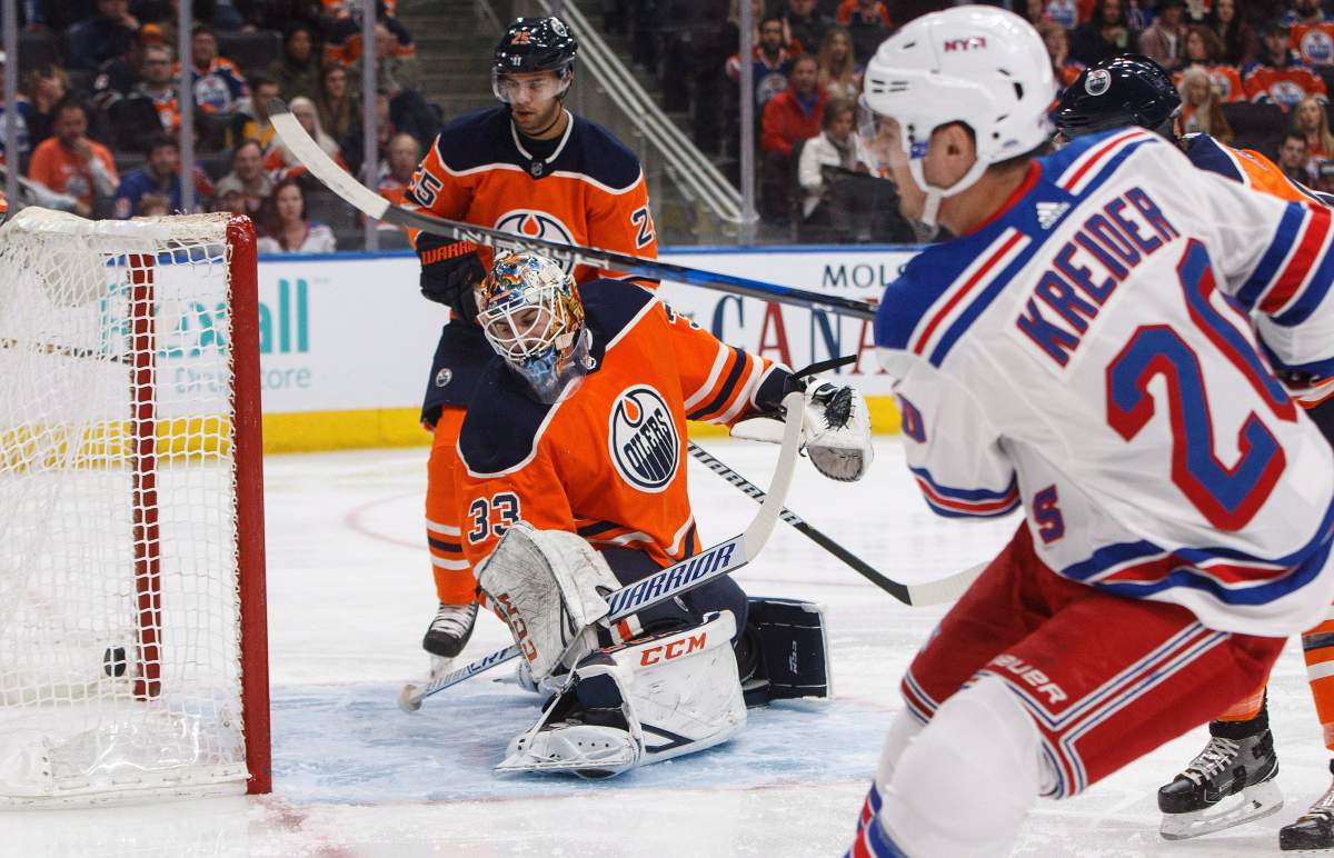 New York Rangers' Chris Kreider (20) scores a goal on Edmonton Oilers goalie Cam Talbot (33) during first period NHL action in Edmonton on Saturday, March 3, 2018. THE CANADIAN PRESS/Jason Franson.