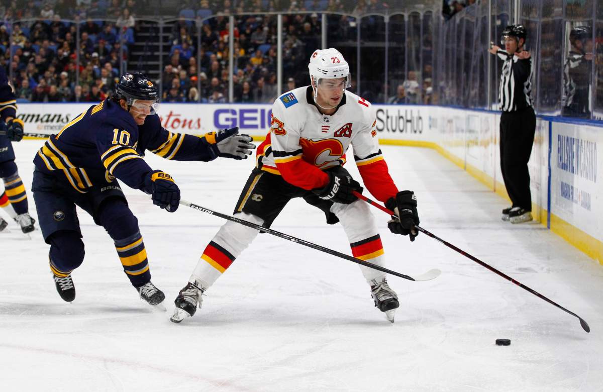Buffalo Sabres Jacob Josefson (10) stick checks Calgary Flames forward Sean Monahan (23) during the first period of an NHL hockey game, Wednesday, March. 7, 2018, in Buffalo, N.Y. (AP Photo/Jeffrey T. Barnes).