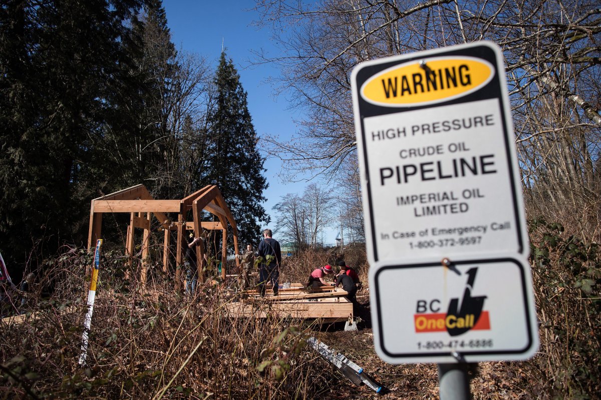 A sign warms of an underground pipeline as people construct a "watch house" near a gate leading to Kinder Morgan's property during a protest against the company's Trans Mountain pipeline expansion in Burnaby, B.C., on Saturday March 10, 2018. 