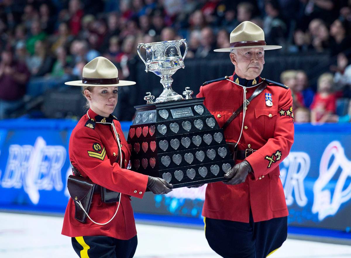 RCMP officers carry the Brier Tankard during the Tim Hortons Brier at the Brandt Centre in Regina on Sunday, March 11, 2018.