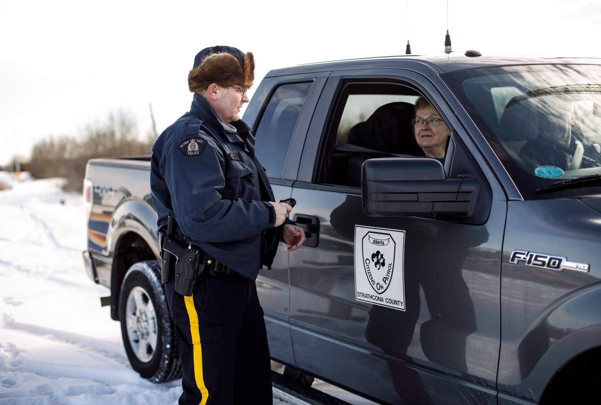 Constable Rick Green speaks about an abandoned car with member of the Alberta Citizens On Patrol Association, Ruth Shewfelt in Ardrossan, Alta., on Tuesday, March 6, 2018. The group have noticed an uptick in crime and have boosted their security measures in response, but are against the idea that property owners have the right to shoot at an intruder.