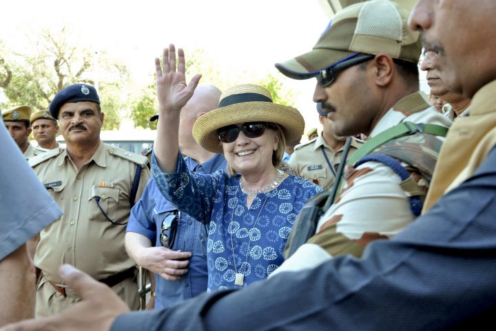 Former U.S. Secretary of State Hillary Clinton, center, waves as she comes out of the Jodhpur airport upoon her arrival in Jodhpur, Rajasthan state, India.