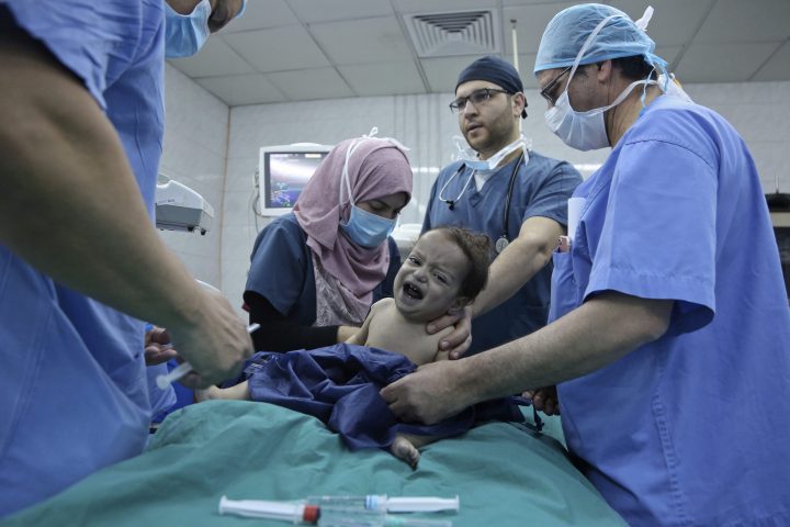 In this March 5, 2018 photo, one-year-old Syrian refugee Eman Zatima is prepared by medical staff for surgery.
