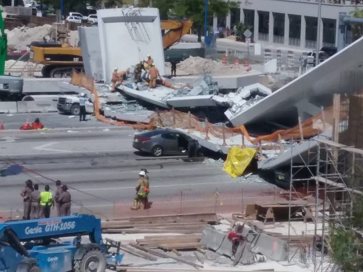 First responders are seen as a pedestrian bridge stretching across a street on the Florida International University campus in Miami collapsed on March 15.