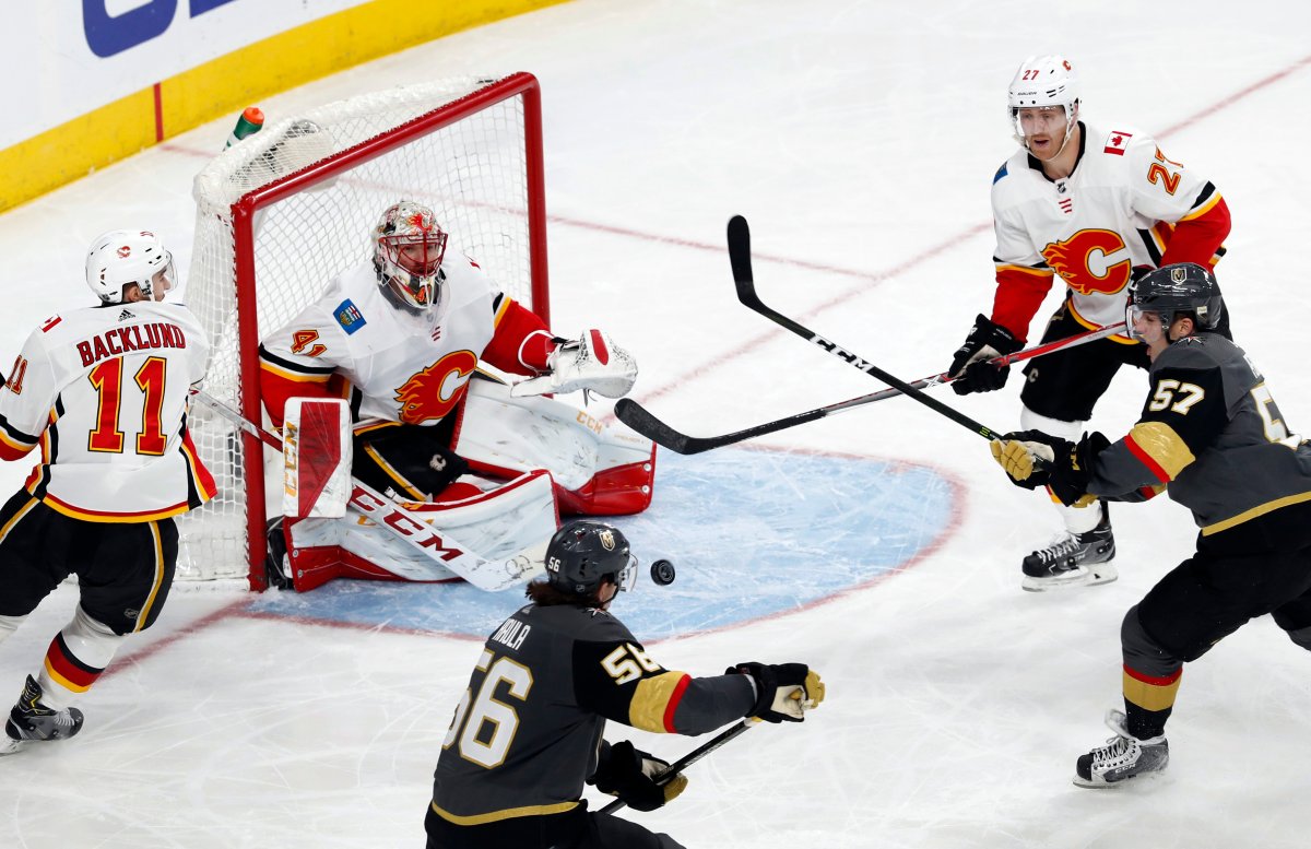 Calgary Flames goaltender Mike Smith (41) blocks a shot by Vegas Golden Knights left wing David Perron (57) during the third period of an NHL hockey game Sunday, March 18, 2018, in Las Vegas. Also pictured are Flames' Mikael Backlund (11) and Dougie Hamilton (27) and Golden Knights left wing Erik Haula (56). 