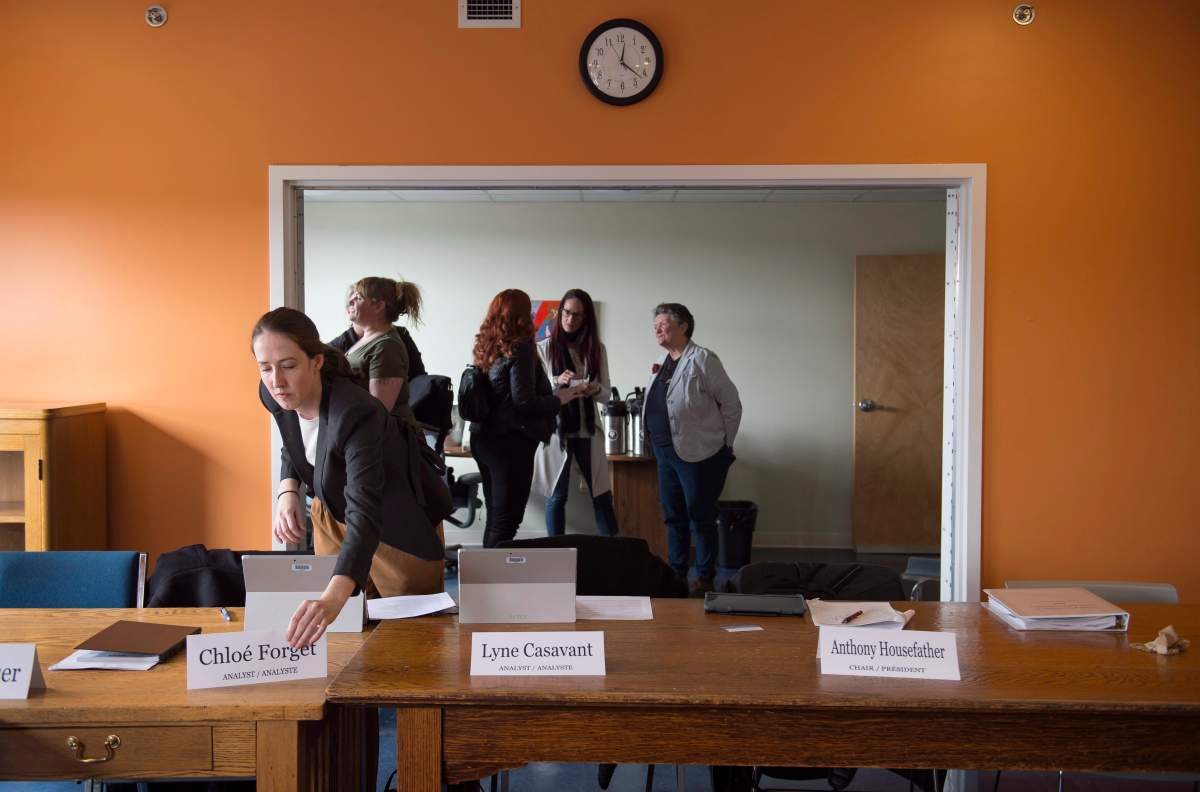 A member of the organizing committee adjusts name placings during a break in the first stop of a cross-country parliamentary committee meeting on human trafficking in Halifax on Monday, March 19, 2018.