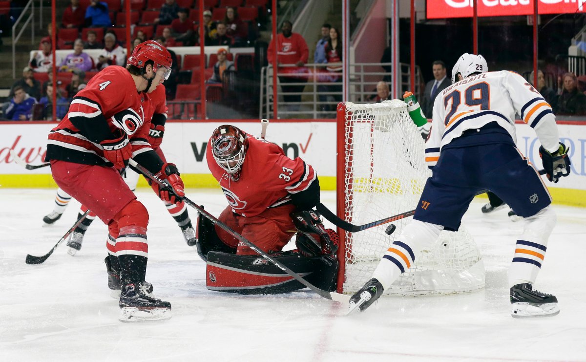 Carolina Hurricanes' Haydn Fleury (4) and goalie Scott Darling (33) defend the goal against Edmonton Oilers' Leon Draisaitl, of Germany, during the first period of an NHL hockey game in Raleigh, N.C., Tuesday, March 20, 2018.
