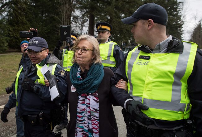Federal Green Party Leader Elizabeth May, centre, is arrested by RCMP officers after joining protesters outside Kinder Morgan's facility in Burnaby, B.C., March 23, 2018. 