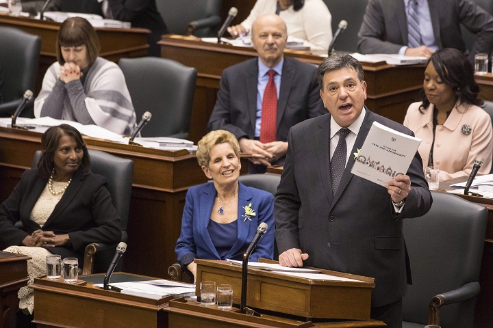 Ontario's Premier Kathleen Wynne (centre) sits next to Provincial Finance Minister Charles Sousa (right) as the Ontario Provincial Government delivers its 2018 Budget , at the Queens Park Legislature in Toronto, on Wednesday March 28, 2018. 