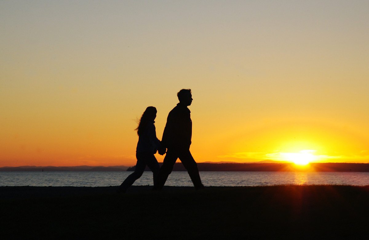 A young couple take an early springtime along Crescent Beach in White Rock, B.C. at sunset. 