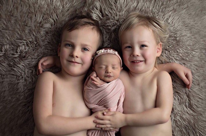 Leah and Adam Jones’ other two children holding newborn baby Rowan.