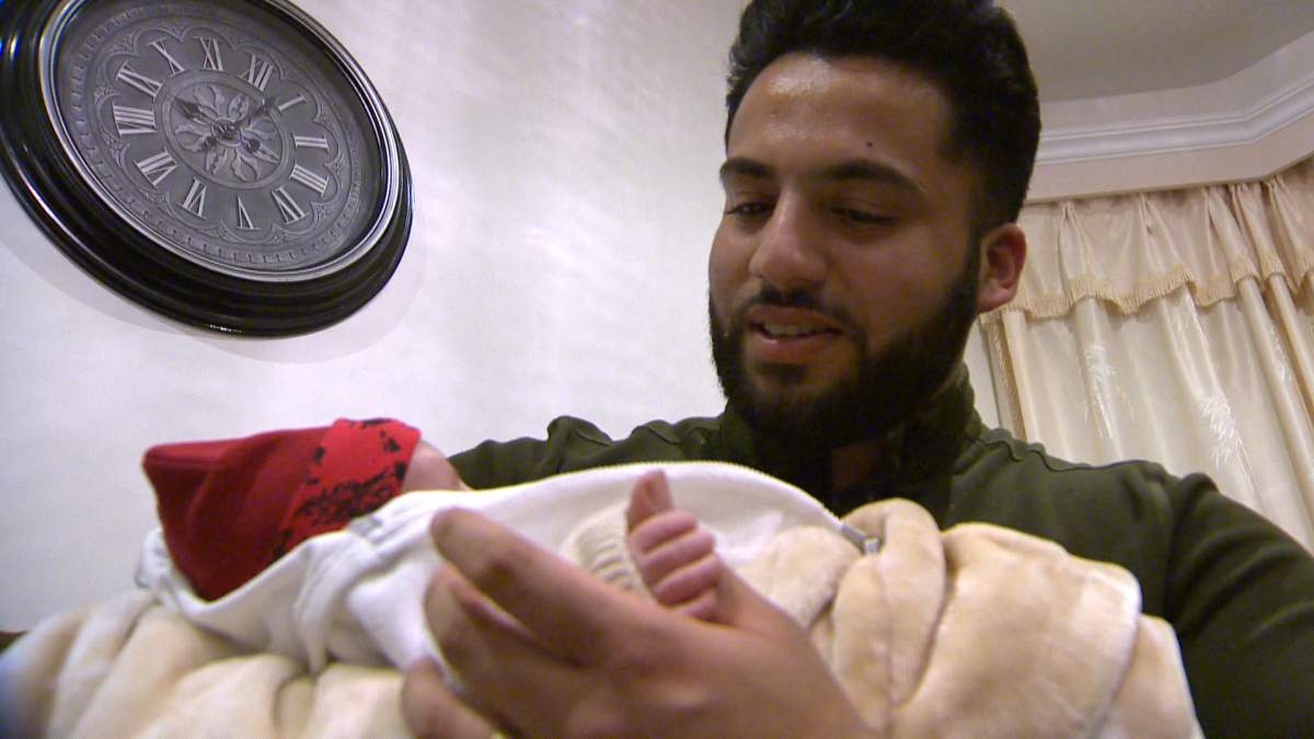 Ahmad Saleem plays with his 4-week-old son Eesa. 