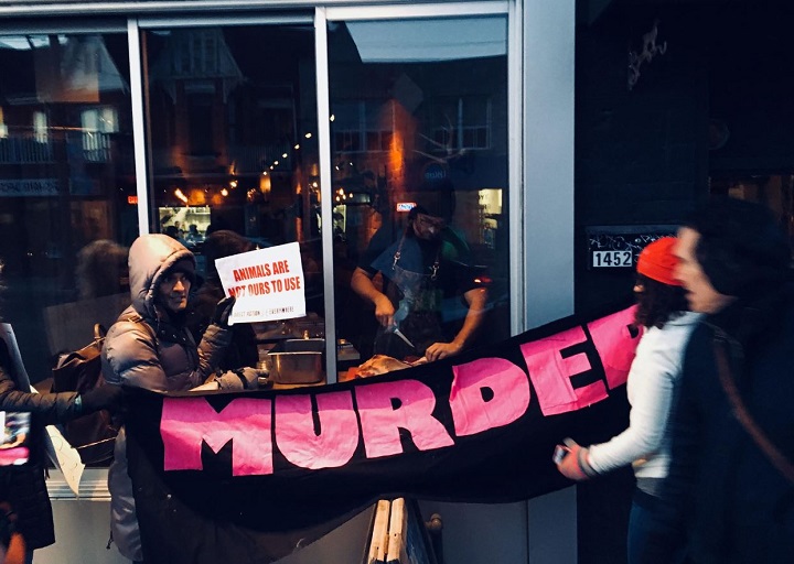 Activists hold a protest outside of Antler Kitchen and Bar on Friday evening.