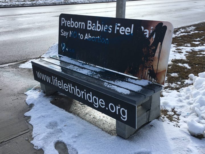 A city transit bench with a pro-life ad that was vandalized. 