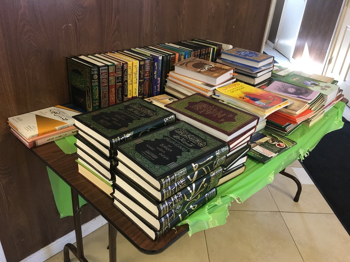 The table of religious books that Solomon appears to sift through in the video.