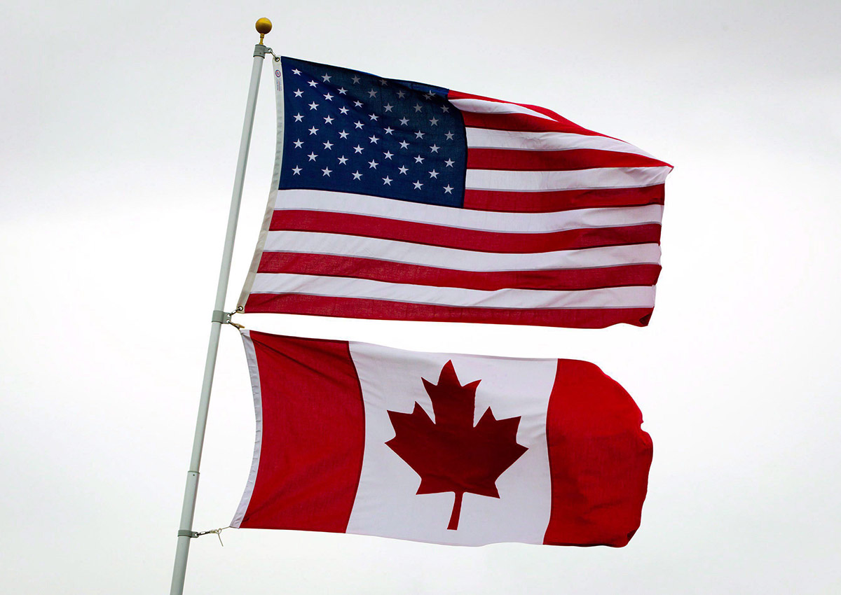 U.S. and Canadian flags fly in Point Roberts, Wash., on Tuesday, March 13, 2012. 