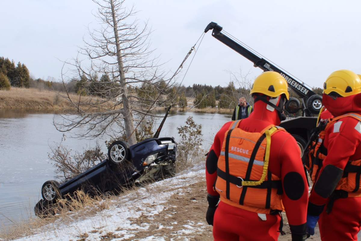 A tow truck removes the car from the Otonabee River.