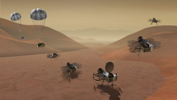 An artist’s rendering shows the proposed Dragonfly quadcopter landing on the surface of Saturn’s moon Titan, unfolding its rotors and lifting off again to survey the landscape and atmosphere.