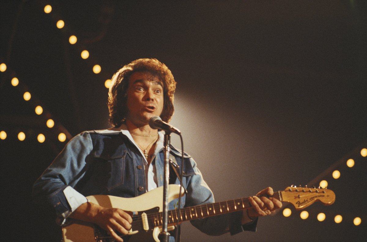 Ronnie Prophet, Canadian country music singer and comedian, playing the guitar during a live performance, circa 1980. 